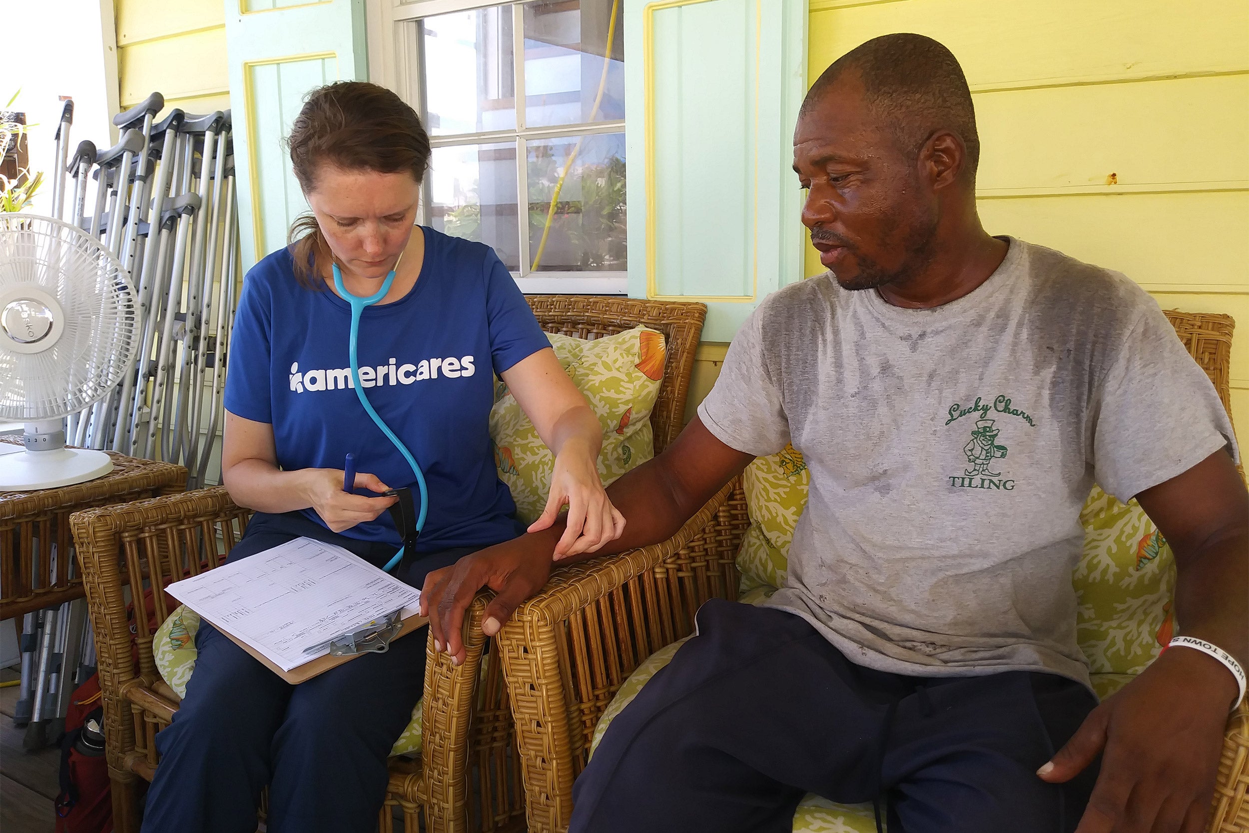 An Americares relief worker examines a Hurricane Dorian survivor.